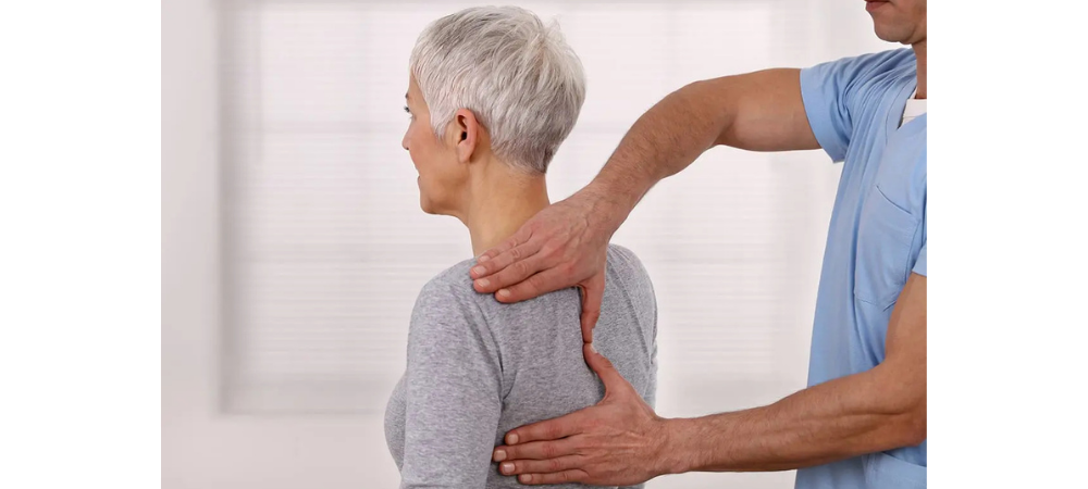doctor assessing upper back of older patient