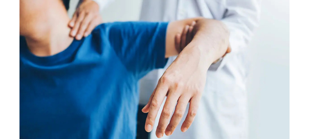 man lifting his arm with help of a doctor checking range of motion