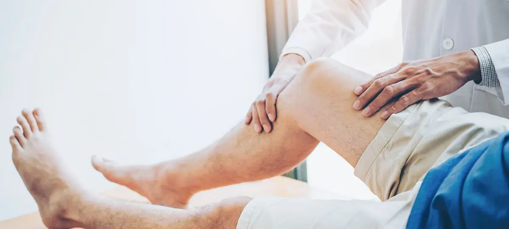 doctor palpating patient knee