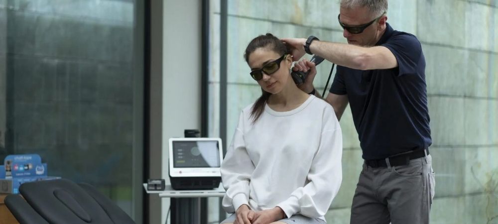 clinician applying laser to patient neck