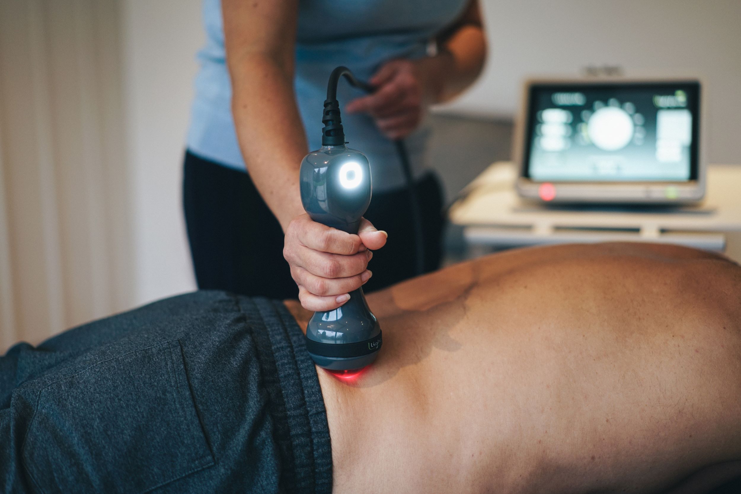 doctor treating patient's back with lightforce laser