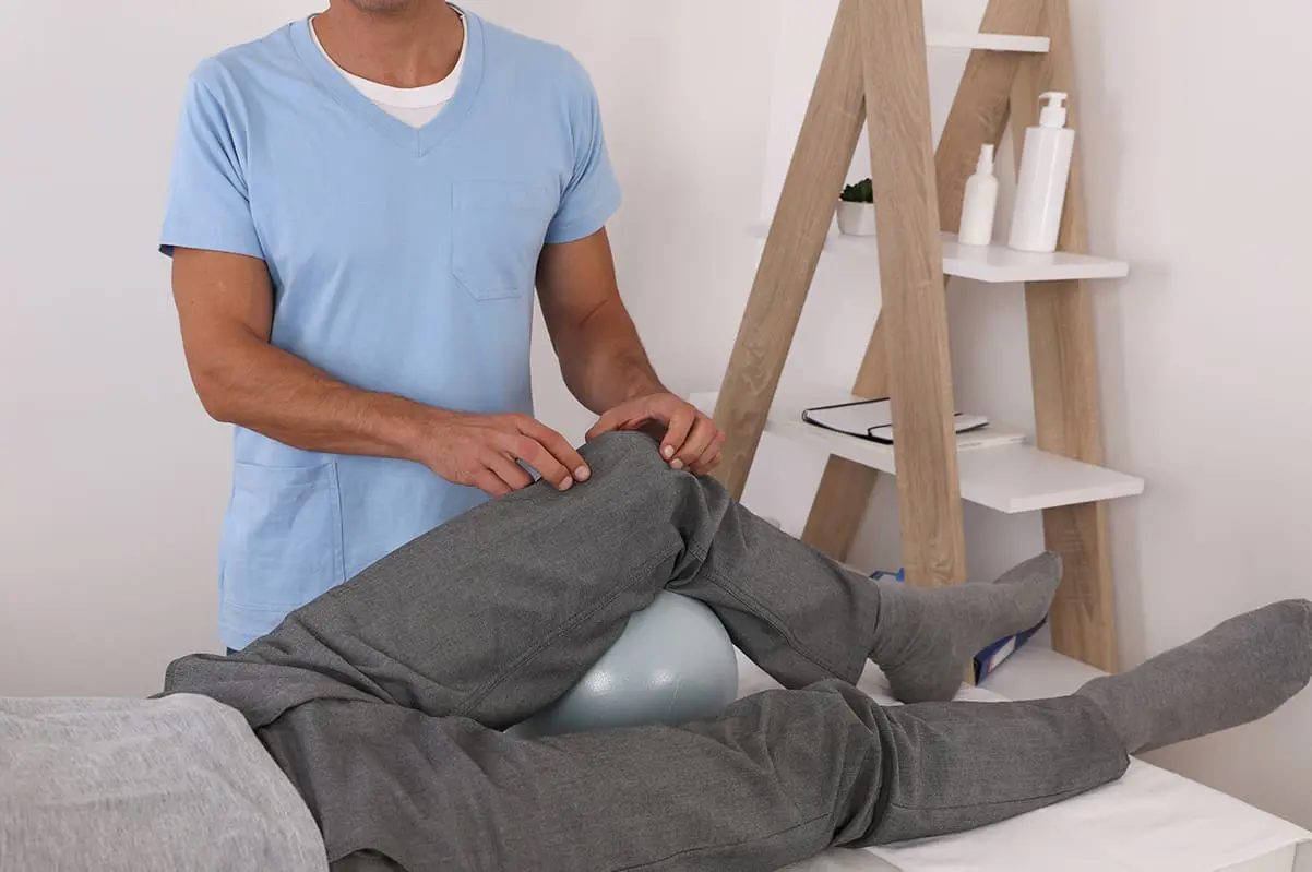doctor palpating patient knee